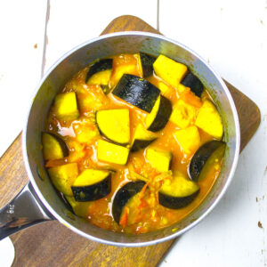 choped aubergine mixed with tomato and ginger sauce in a pan