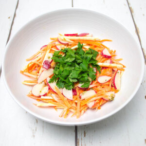 celeriac remoulade topped with chopped parsley arranged in a white bowl