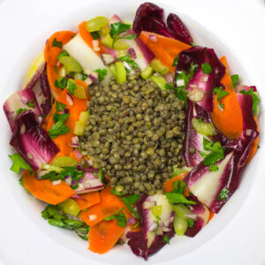 chicory salad with chopped vegetables and parsley and lentils in the middle