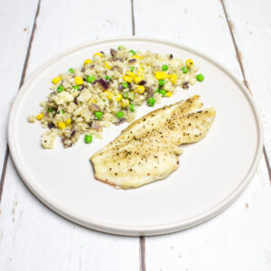 baked white fish and cauliflower rice with red onion, peas and corn arranged on a white round plate