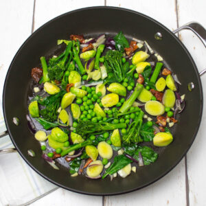 lots of green chopped vegetables and a little bit of olive oil in a frying pan