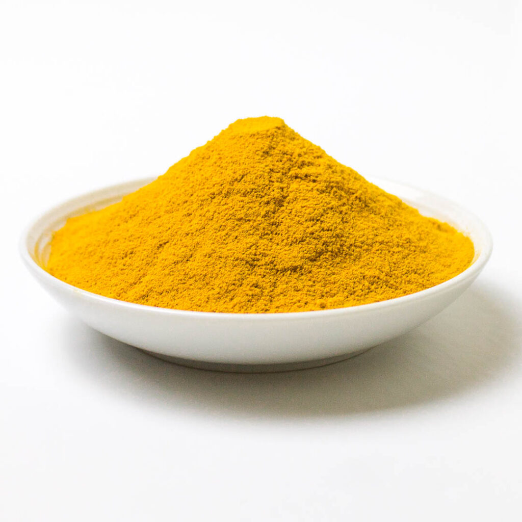 a pile of a ground turmeric on a place on a white background